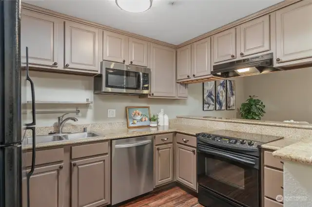 Roomy kitchen with lots of cabinets and appliances including refer, microwave, range & fan, dishwasher, dbl stainless sink with sprayer faucet. Stone countertops. Nice!!