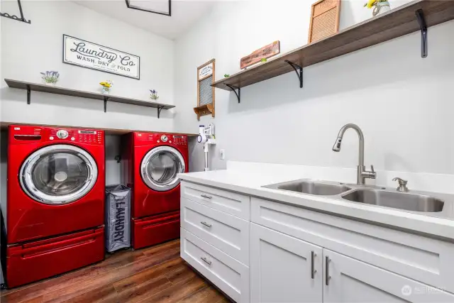 Laundry Room  Washer and dryer on pedestals  Folding counter  Double stainless sink with pull out sprayer want and soap dispenser    Soft close cabinets & drawers  Hanging clothes racks