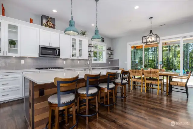 8’ x 4’ Island with barnwood detail. Eating bar with solid wood soft close drawers and doors, farm sink, pull out wand, and dishwasher next to sink