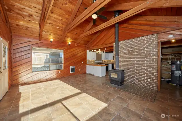 This open living area has ceramic tile flooring and a wood burning stove to warm your inviting space. The stove is a great feature that adds charm and warmth to the room.