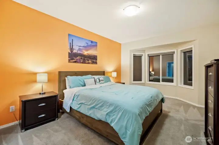 Primary suite on main level with bay window overlooking greenery