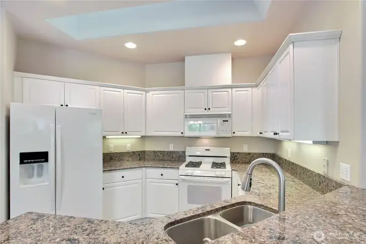 Open kitchen with dining pensinsula and granite counters. Undercabinet lighting and gas range!