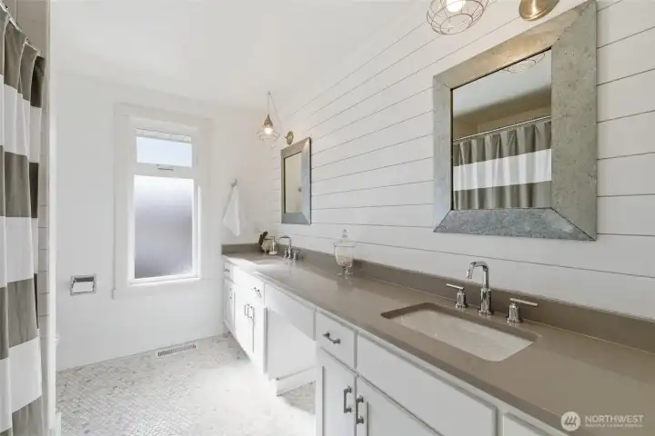 upstairs hall bath with double sink and bathtub/shower