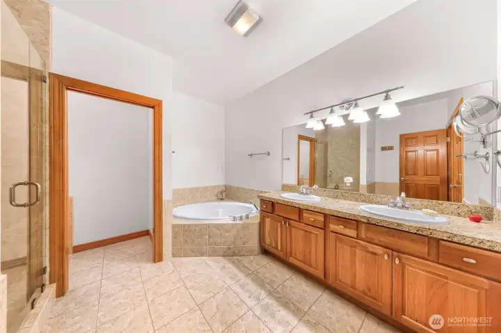 Primary bathroom with double sinks and jetted tub, private bidet room and oversized shower with custom glass shower doors.