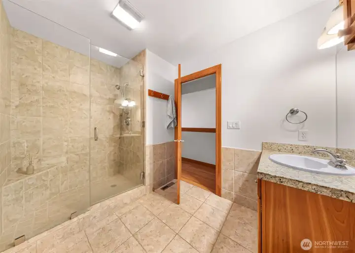 Upstairs 3/4 bathroom with tile shower and custom oversized glass shower doors.