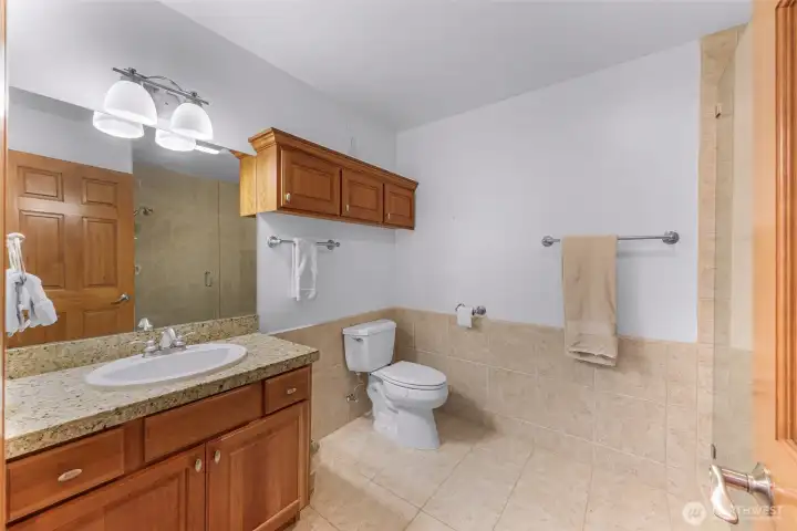 Upstairs 3/4 bathroom with tile shower and custom glass doors.