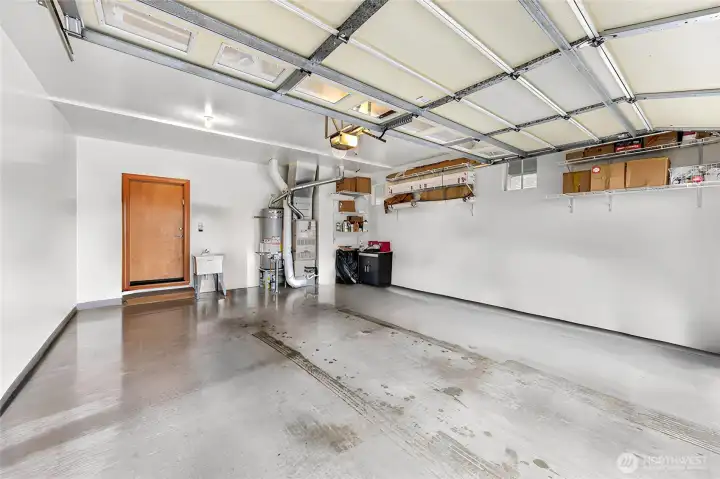 Garage with epoxied floors and wash basin. Door leads into dedicated laundry room.