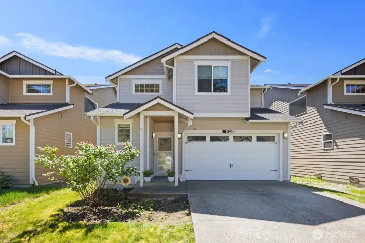 Front exterior view featuring contemporary siding, a covered porch, and spacious driveway.