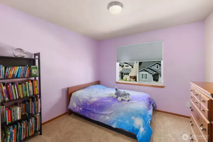 Additional upstairs bedroom with large window and spacious layout.