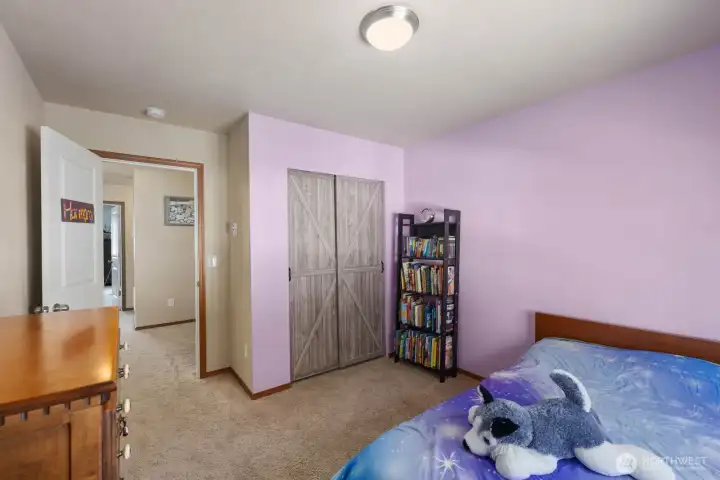 Upstairs bedroom with carpet flooring and natural light.