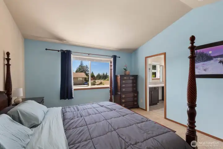 Primary suite with neutral carpet, generous layout, and attached ensuite bathroom.