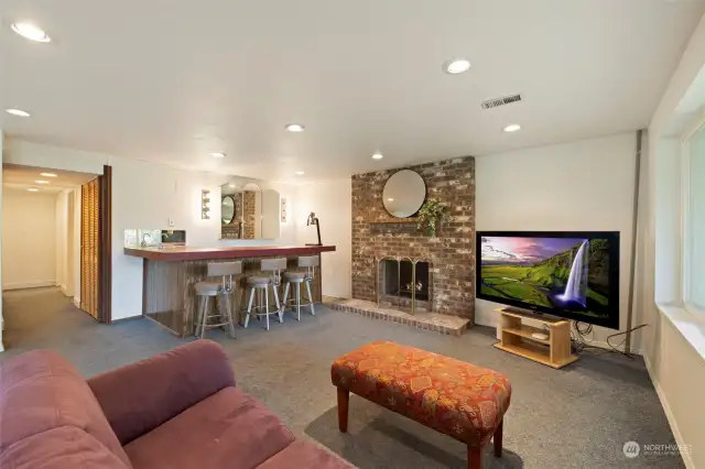 the lower level family room/recreation room has tons of space to play and do as you wish. wood burning fireplace and wet bar, built in bookcases and exit to patio and backyard.  It's super light and bright.
