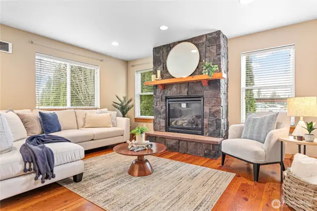 Cozy living room open to kitchen w/stone gas fireplace & rustic pine floors