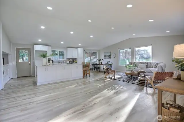 Open living room with vaulted ceilings is bright and light filled.