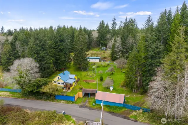 The home and outbuildings are located on the two parcels above Power's Creek Rd. Together they consist of approximately 11 acres, partially fenced. This photos gives you a pretty good look at the shop/rec room building on the lower right. And the other multi purpose building further up the hill.