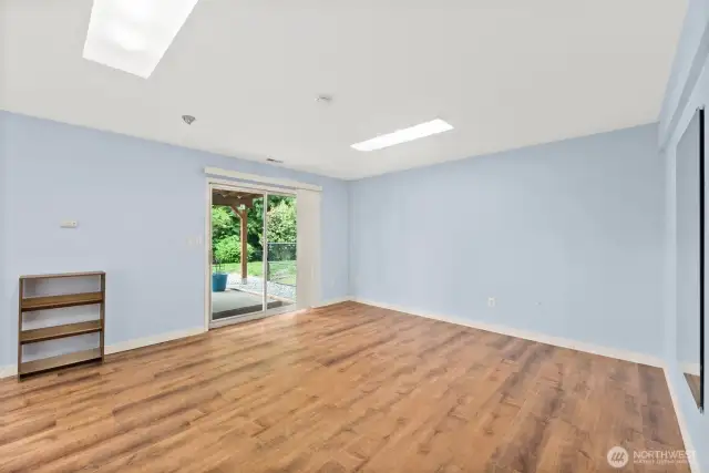 Ample lower level great room with pellet stove and doors that step out onto the fenced yard patio.
