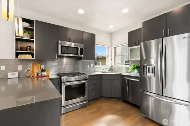 Kitchen has ample storage space, a corner window above the sink, and a nearly brand new gas range.