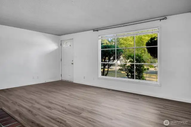 Large Living room with picture window facing west.  Laminate floors over Oak hardwood.