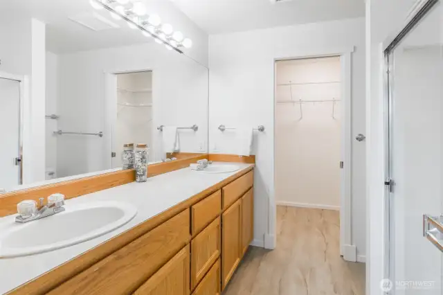 Primary suite bathroom with walk in closet beyond.
