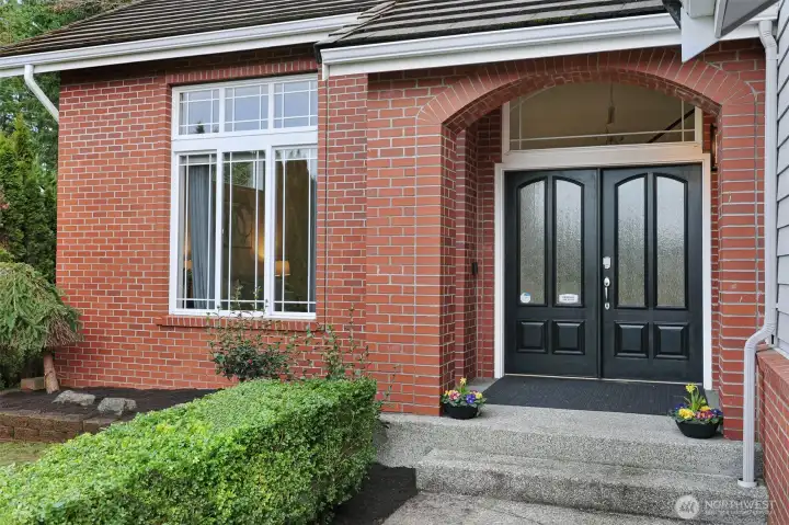 An elegant double-door entry with covered porch welcomes you home.