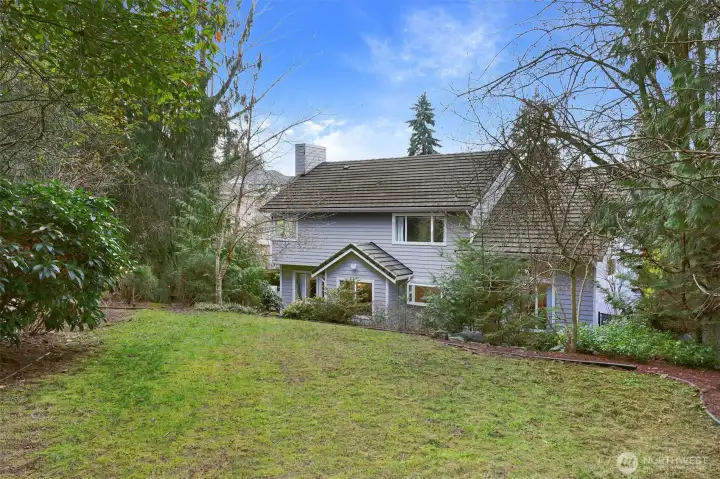The upper terrace features a grassy lawn bordered by lush landscaping.
