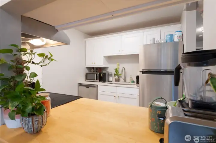 Updated kitchen with modern, Shaker cabinetry and smart, stylish design. This pass through offers convenience for serving from the kitchen to the dining room.