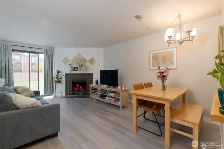 Appreciate the convenience of LVP flooring, a cozy wood burning fireplace and slider to the back patio and community areas.