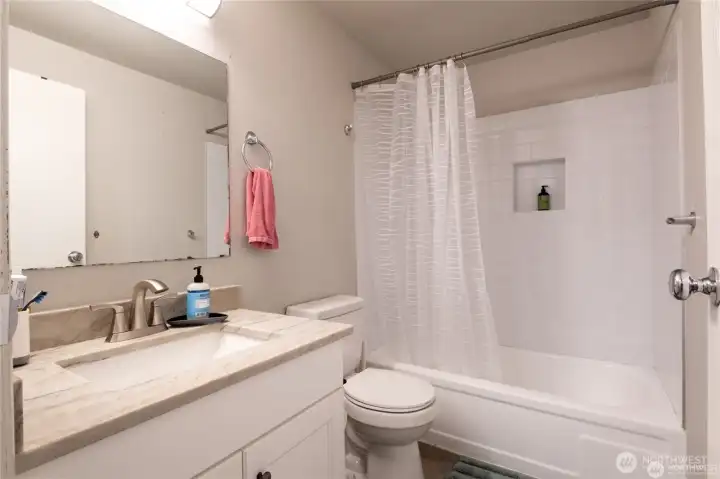 Updated full Guest bathroom with new cabinetry and countertops, and a clean, modern design.