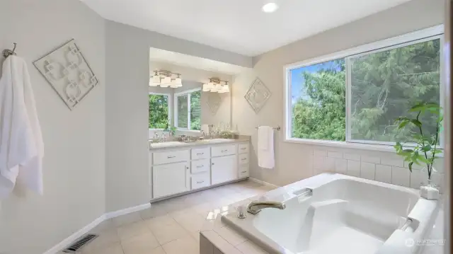 The primary bath is spacious with a soak tub and separate shower.  Tile floors and granite counters.