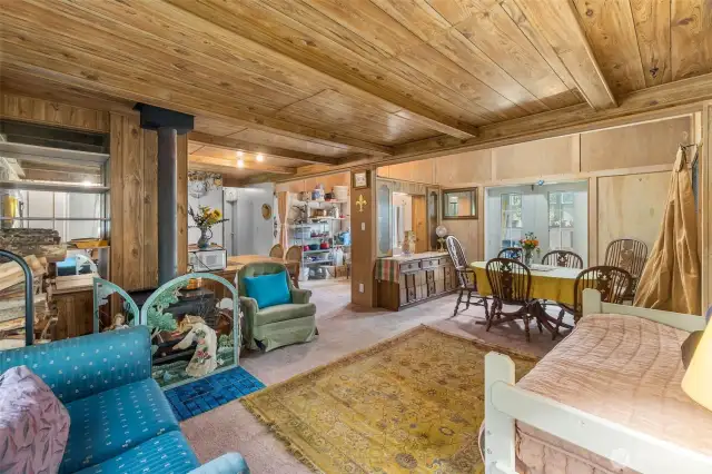 Front door entrance looking over living room with wood stove, dining area with french door leading to sun room