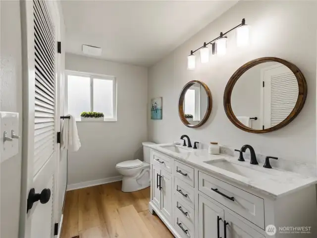 Remodeled primary ensuite with tile shower, double vanity & walk-in closet.