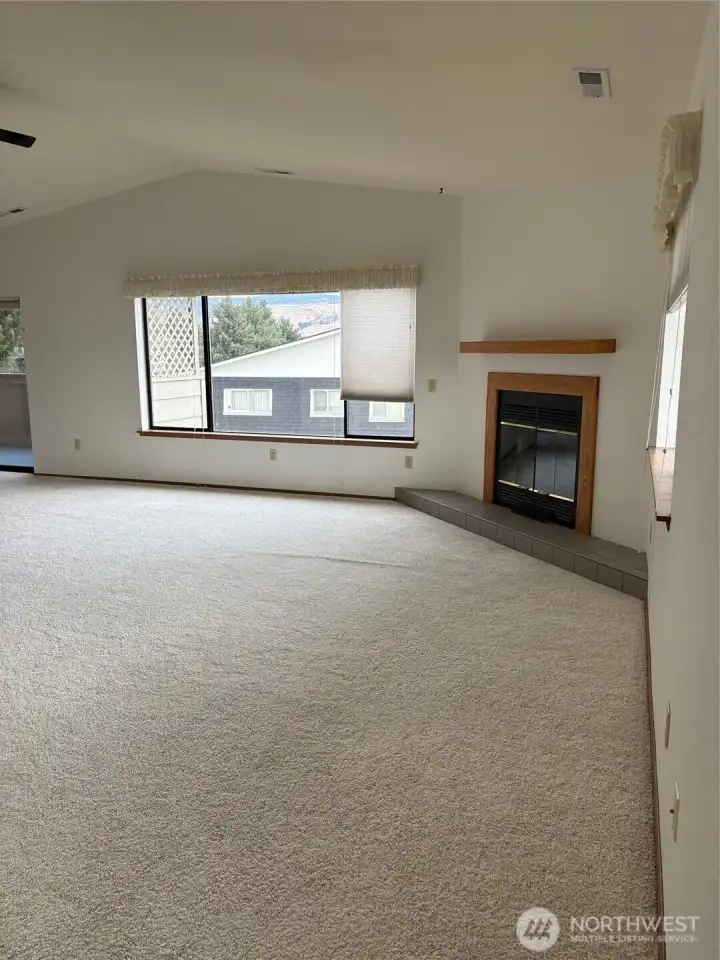 Living room with vaulted ceiling and fireplace.