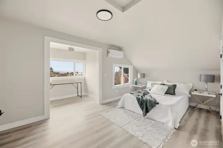 The serene primary bedroom is bathed in natural light from its generous windows, creating a bright and welcoming retreat.