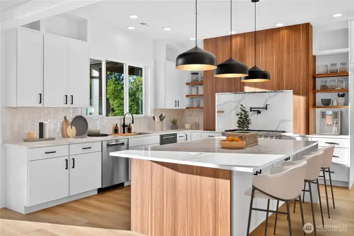 Spacious kitchen with gorgeous Lake Sammamish views from the window, featuring a large range, two Bosch dishwashers, a built-in microwave in the oversized island, and a high-end Dacor refrigerator.