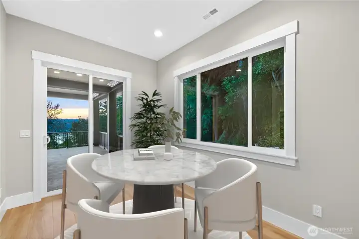 Second eating area off the kitchen with views of Lake Sammamish and the Native Growth Protection Area. A dedicated sliding door leads to a covered section of the wraparound deck, complete with year-round heating elements.
