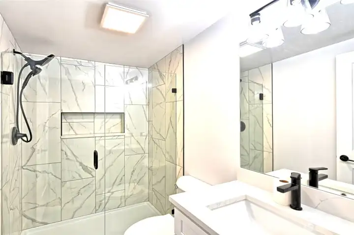 Custom primary bathroom with upscale full tile shower enclosure, glass door, all new fixtures