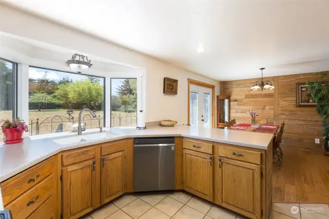 The kitchen is laid out to synchronize with the big bay window behind the sink. The window affords a sweeping view of the yard, and the layout makes the kitchen easy to work in.