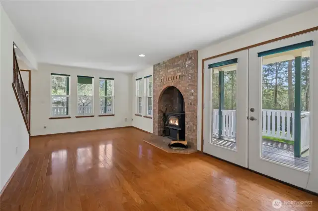 Large, open living room surrounded by windows and a wrap around deck.