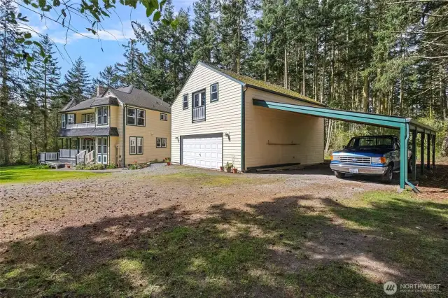The carriage house features a large two car garage, attached two car carport, and a versatile living space upstairs.