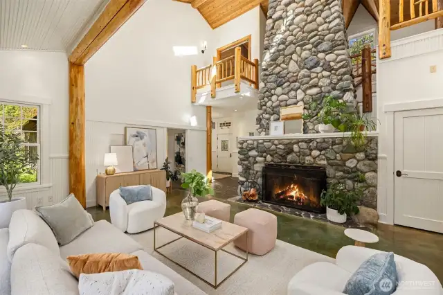This fabulous living room somehow manages to be impressive and cozy at the same time. Note the lofted spaces above, overlooking the living room. The dramatic wood-burning stone fireplace is both beautiful and functional! It was designed with a parallel liner and a fan to return heated air back to the main floor, controlled by a rheostat switch.
