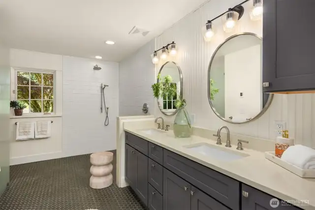 The large primary bathroom was recently renovated. The curbless shower provides the same heated floors found on the entire main level. Such a luxury! A large walk-in closet is just behind the photographer in this shot (see virtual tour).