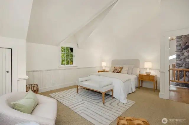 The upstairs en-suite bedroom’s dormer windows offer both a charming architectural touch and elevated views of the grounds.