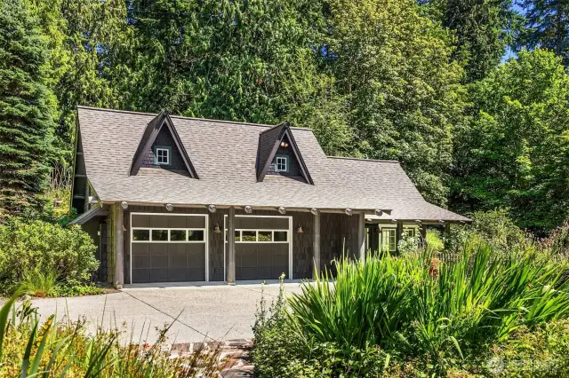 Here, we see the detached garage with studio space, as seen from the front path of the main home.The paved area is large enough to allow access to the garage as well as additional parking, if needed.