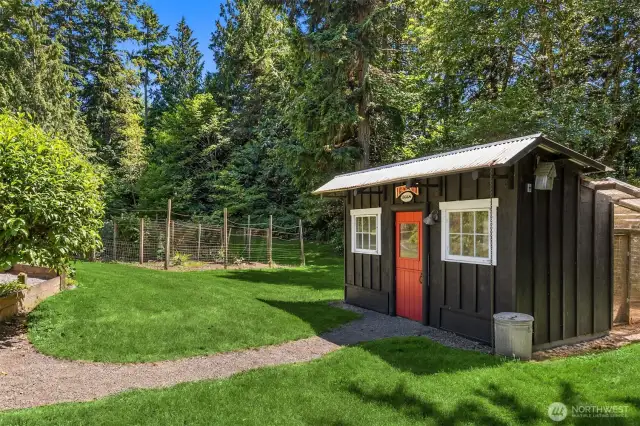 This super deluxe chicken coop features a predator-proof run, an exhaust fan, multiple areas for your flock, a watering system, nesting boxes, and more! The fully-fenced berry patch is seen in the background.
