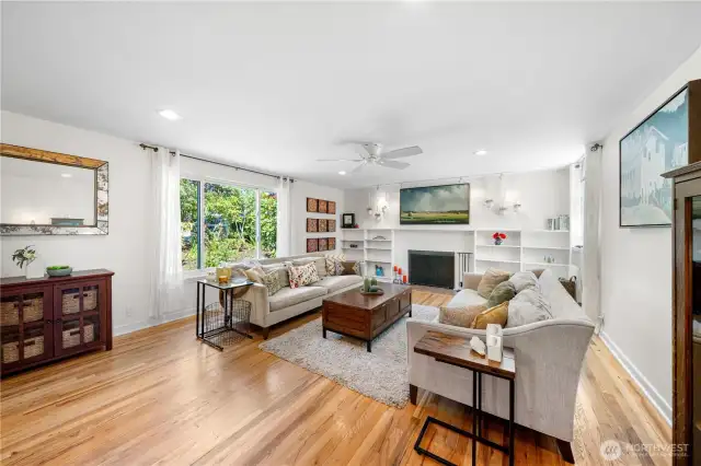 Bright & private living room w/ centerpiece fireplace framed by built-in shelving.