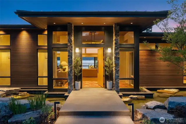 Stunning vaulted entry with floating walkway, over the custom water feature.