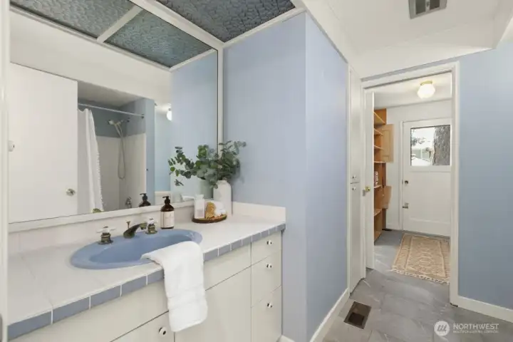 Main floor full bath which opens to utility room and hallway.