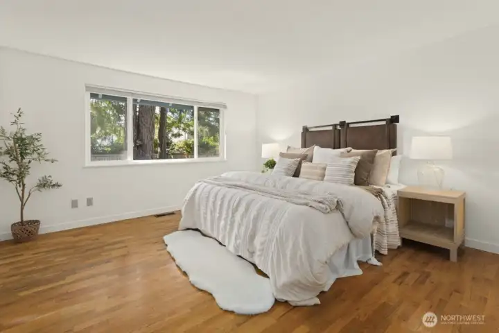 Main floor primary is just full of natural light and just look at those gorgeous oak hardwood floors!