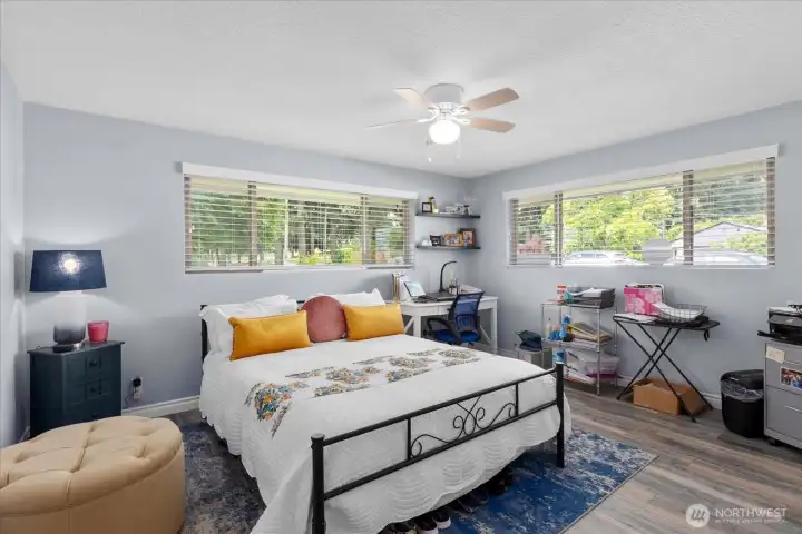 Bright secondary bedroom with large windows and flexible space for sleeping, work, or hobbies.
