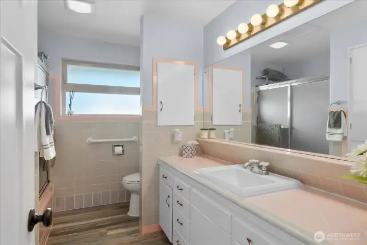 Generous bathroom with extended vanity, classic tile detail, and abundant counter space.